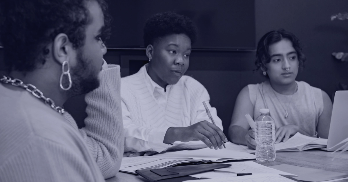 queer and trans employees sitting at work table