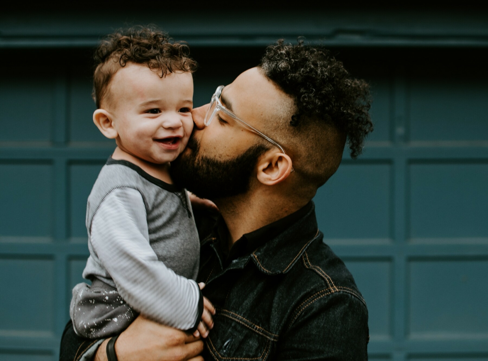 Father kissing young baby on cheeks