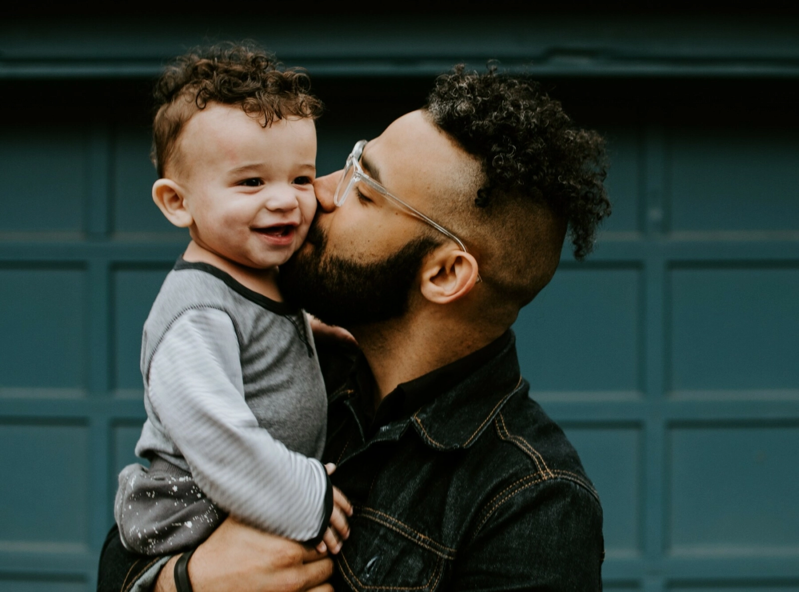 Father kissing young baby on cheeks
