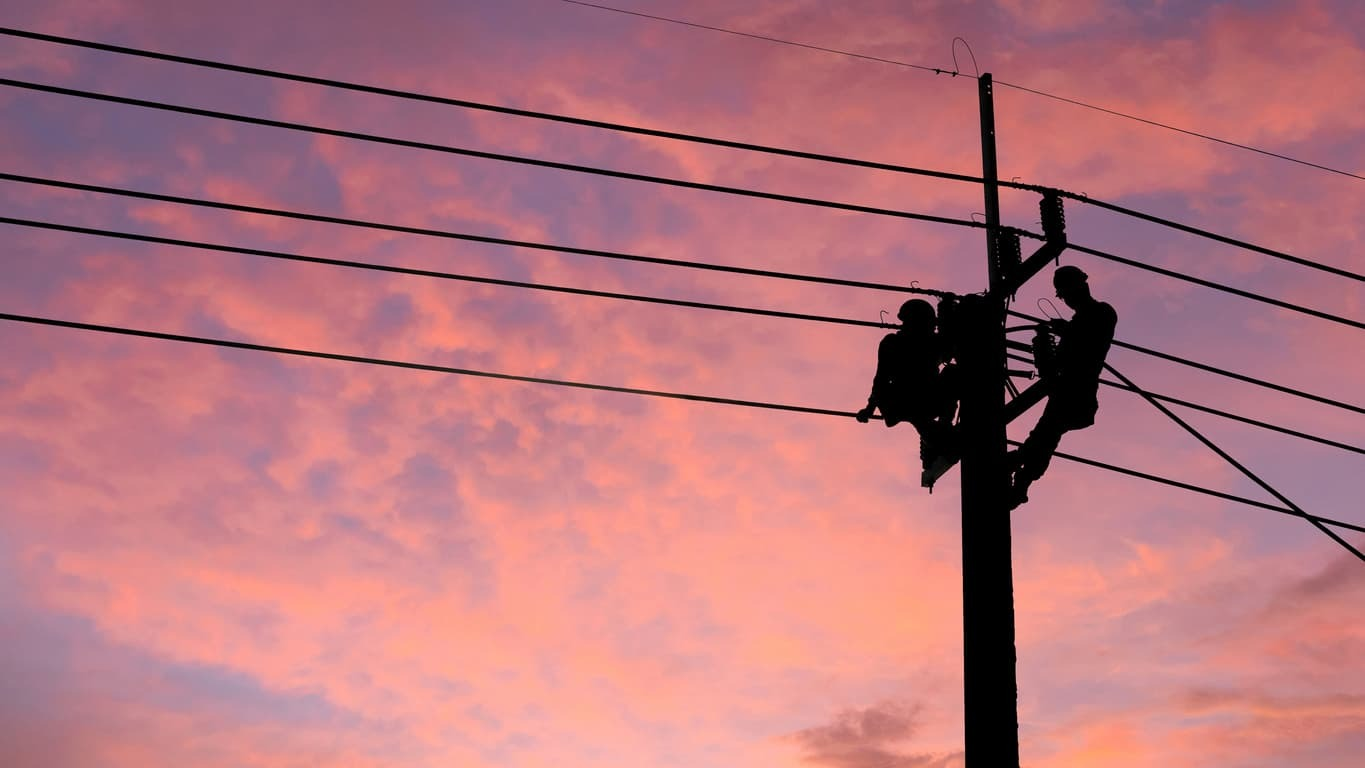 Two people working on a powerline