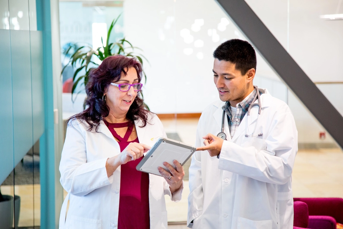 two healthcare professionals discussing a patient chart