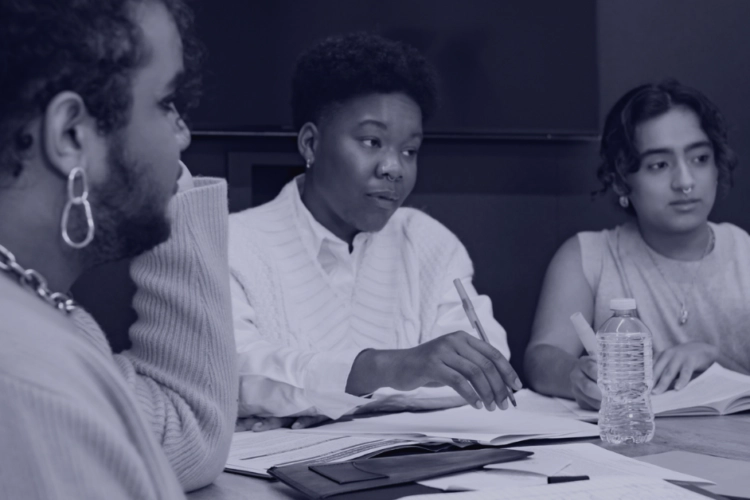 queer and trans employees sitting at work table