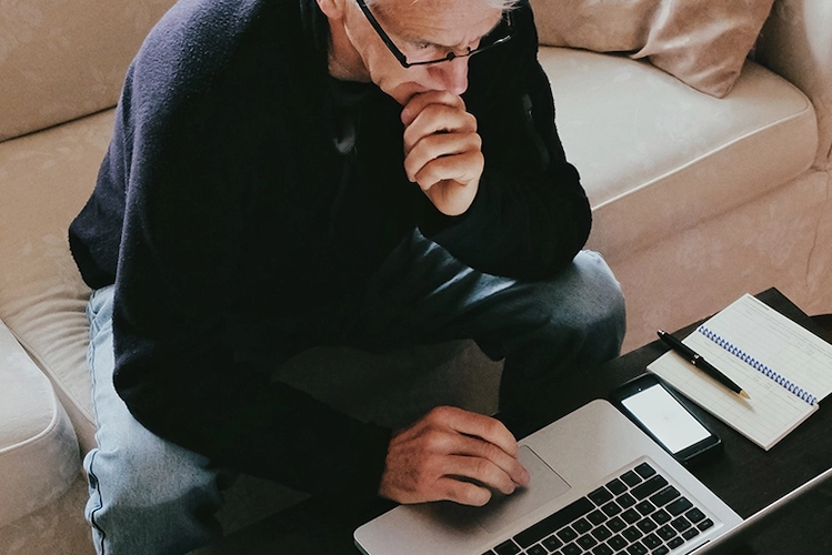 man working on laptop from couch