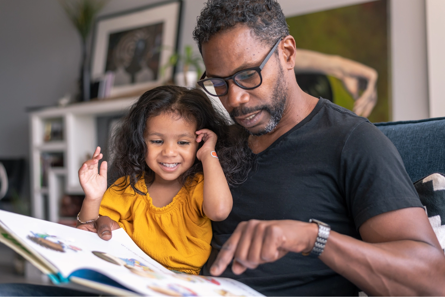 father and daughter reading on the couch