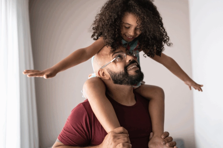 girl sitting on her dad's shoulders