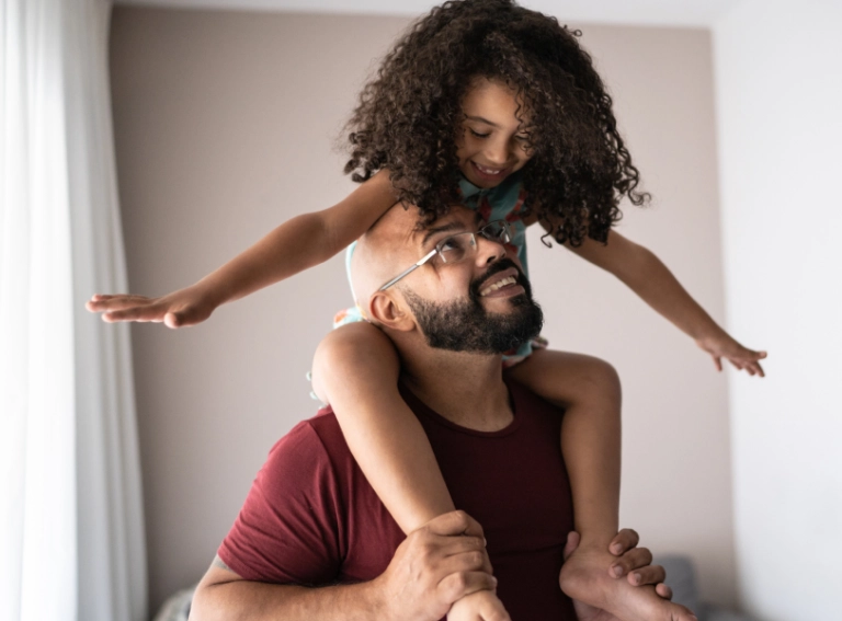 girl sitting on her dad's shoulders