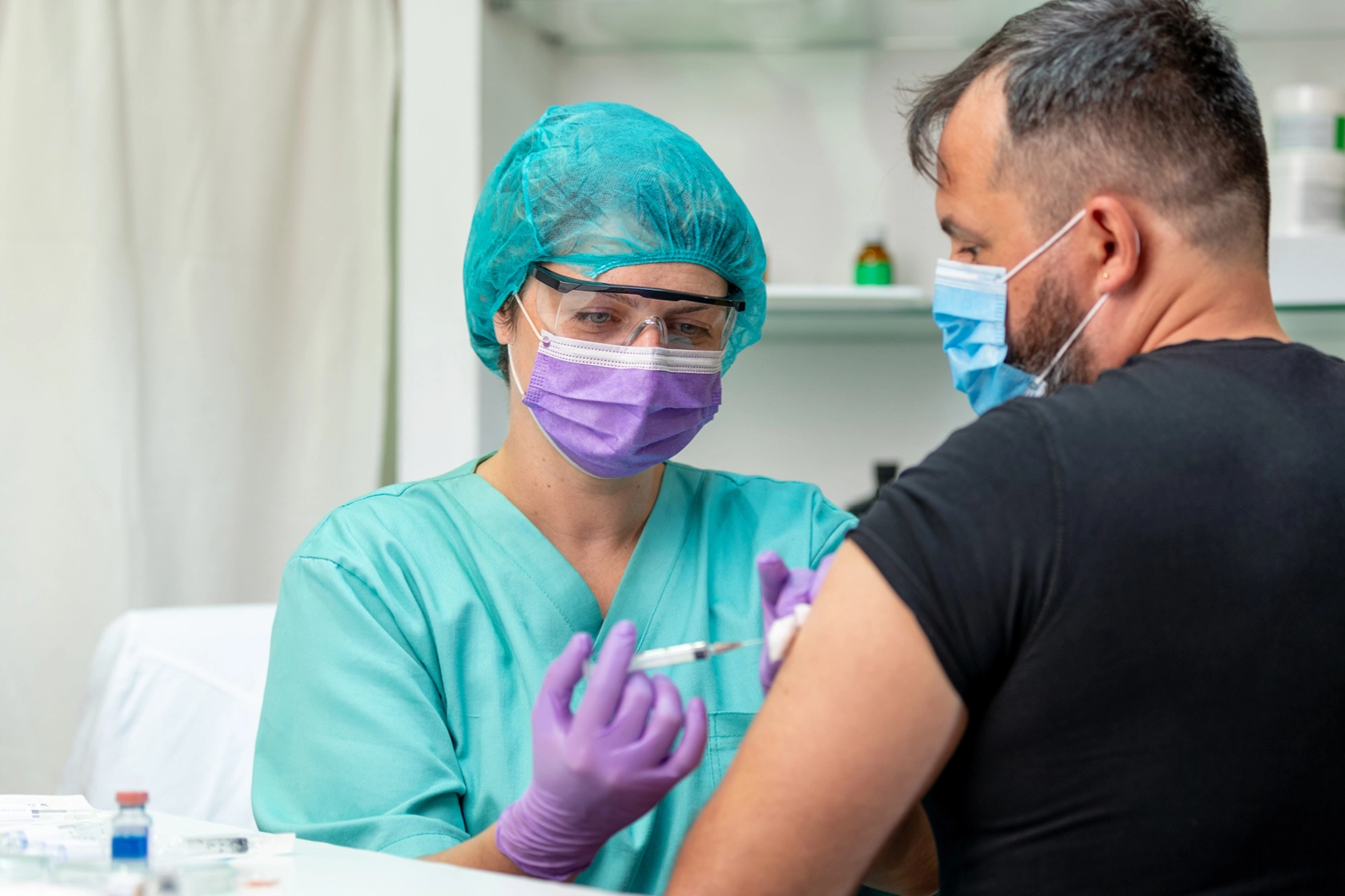 doctor injecting shot into patient's arm