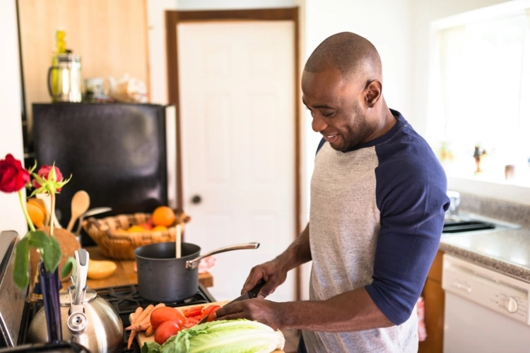 young man cooking with vegetables