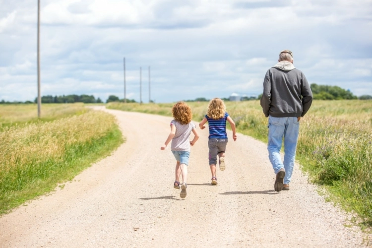 dad and 2 kids walking in rural town