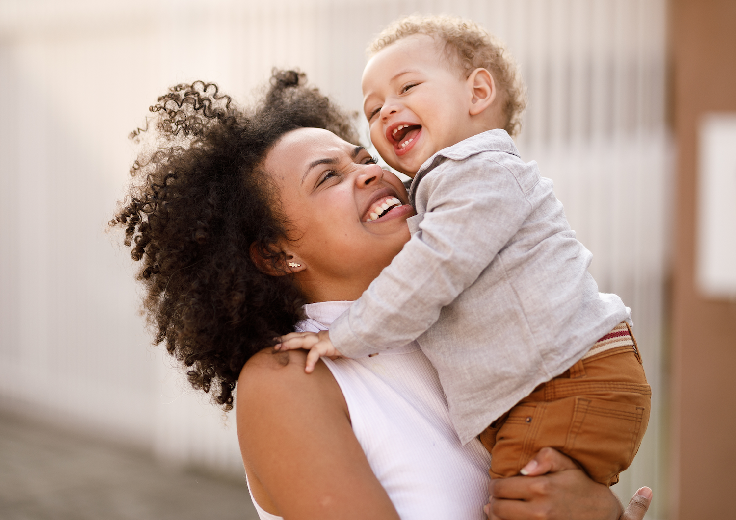 mom holding her adorable baby both laughing