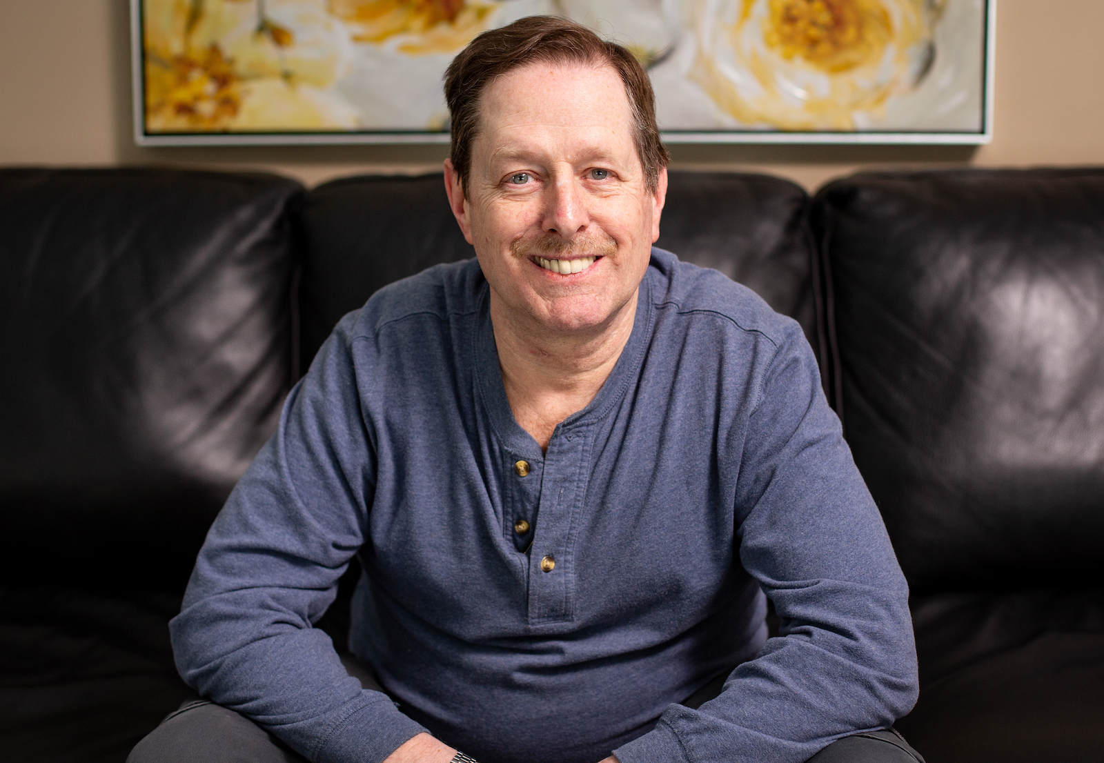 Man sitting on sofa smiling