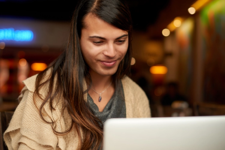 Trans person smiling looking at computer