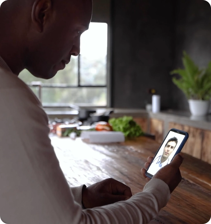 Man in kitchen on smartphone in telehealth call