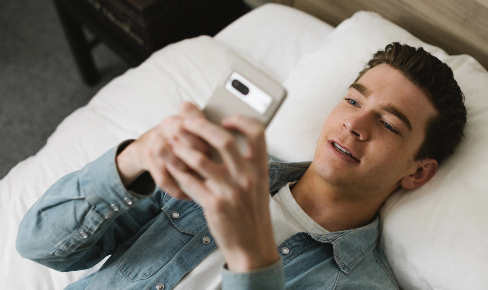 Man with smartphone on bed
