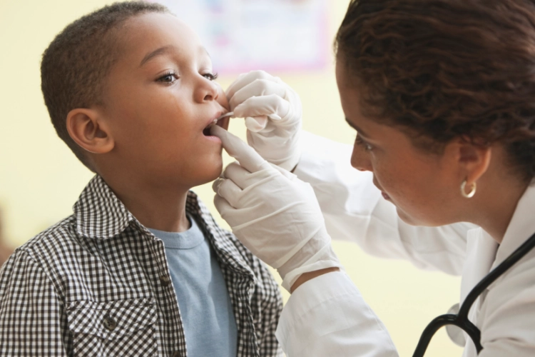 Doctor looking into child's throat
