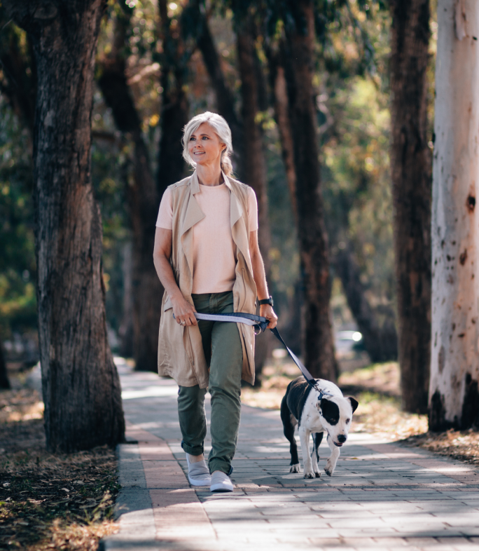 woman walking dog on path