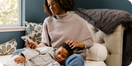 mom with sick child on couch.
