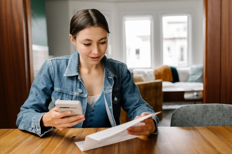 Woman sitting at table trying to figure out medical bills.