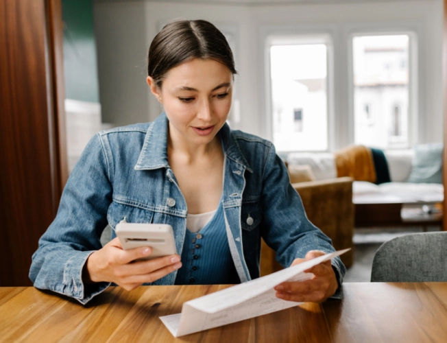 woman with smartphone and piece of paper
