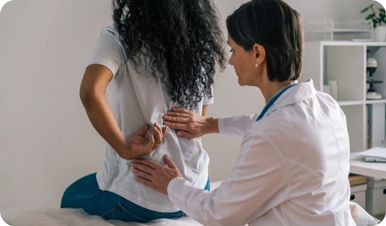 doctor looking at a patient's back and spine.