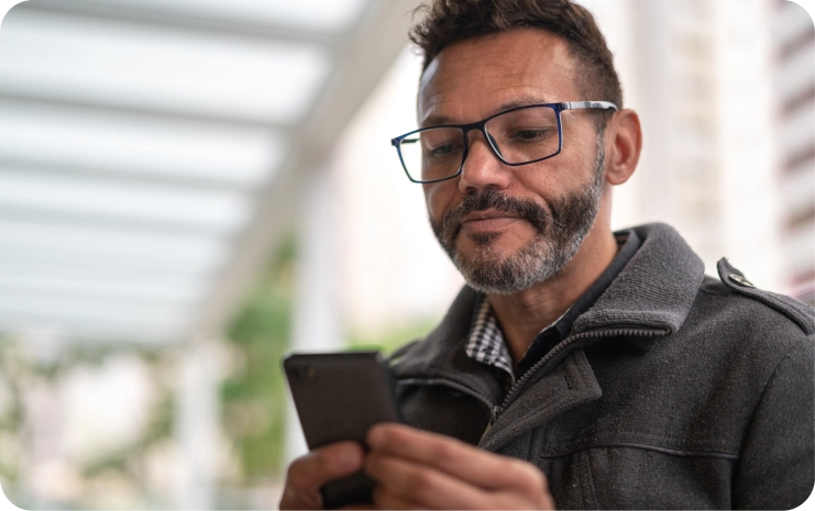 While looking at his phone, a man books a virtual therapy visit