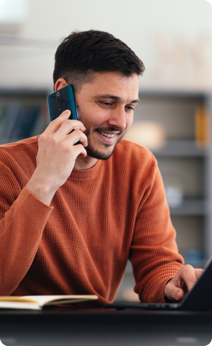 A man talks on the phone while at work