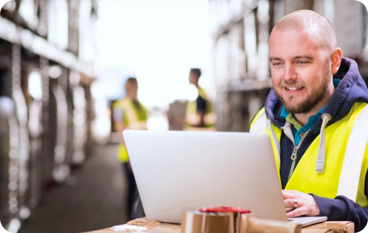 A worker in a safety vest books a primary visit from a warehouse
