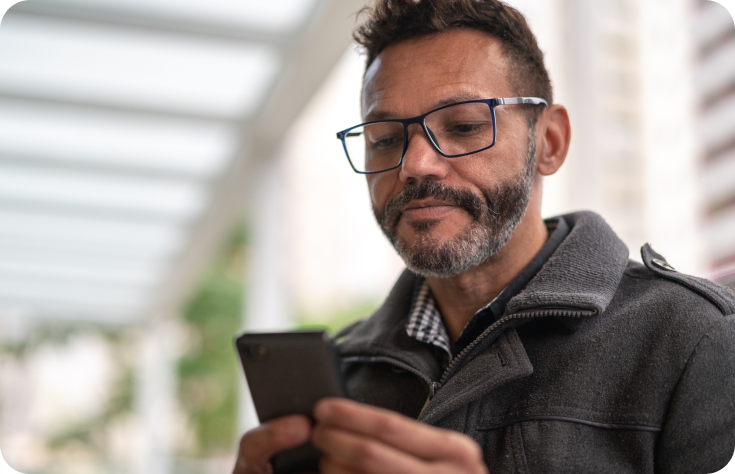 While looking at his phone, a man books a virtual therapy visit