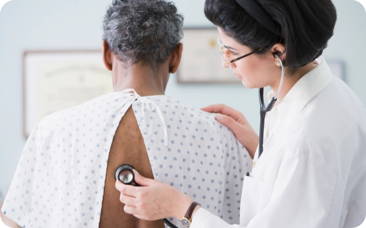 A female doctor examines a patient who is having spinal issues