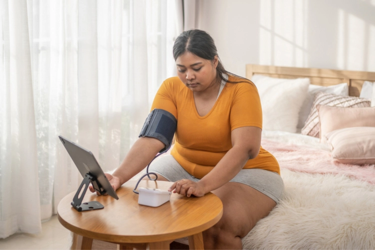 patient taking her blood pressure at home for virtual care visit
