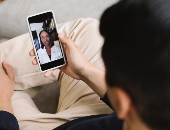man on phone using Included Health app