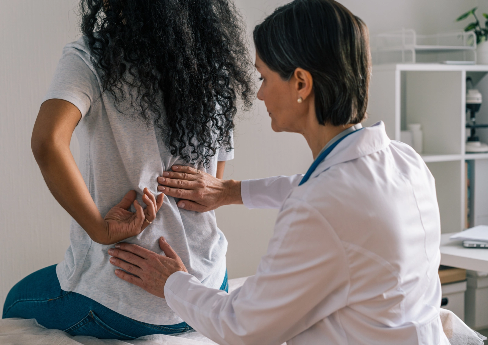 female doctor giving a back exam to woman patient