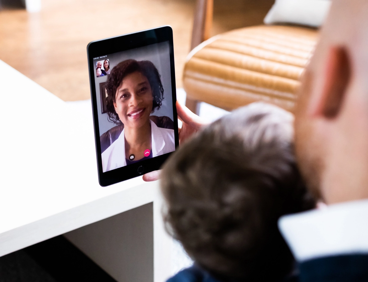 man and child in telemedicine call on tablet