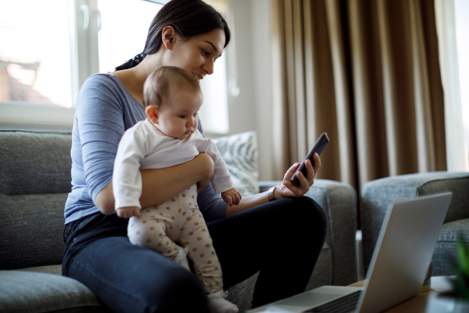 mom holding baby on phone using Included Health app