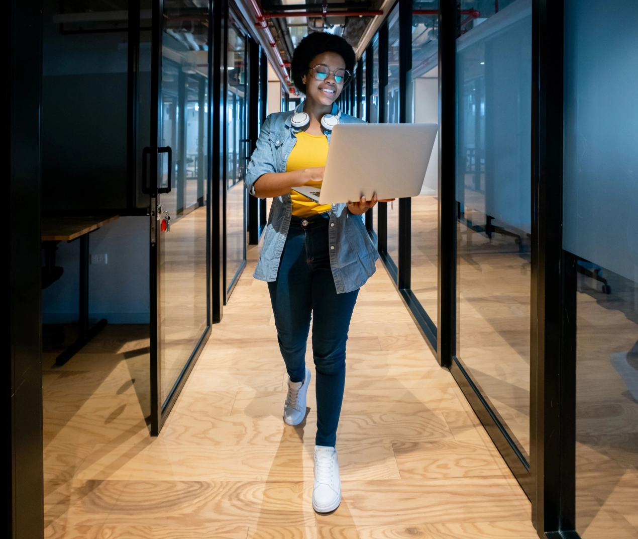Person with laptop walking through office