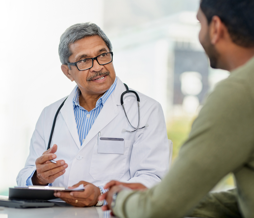 Hombre incluido Médico de salud hablando con un paciente