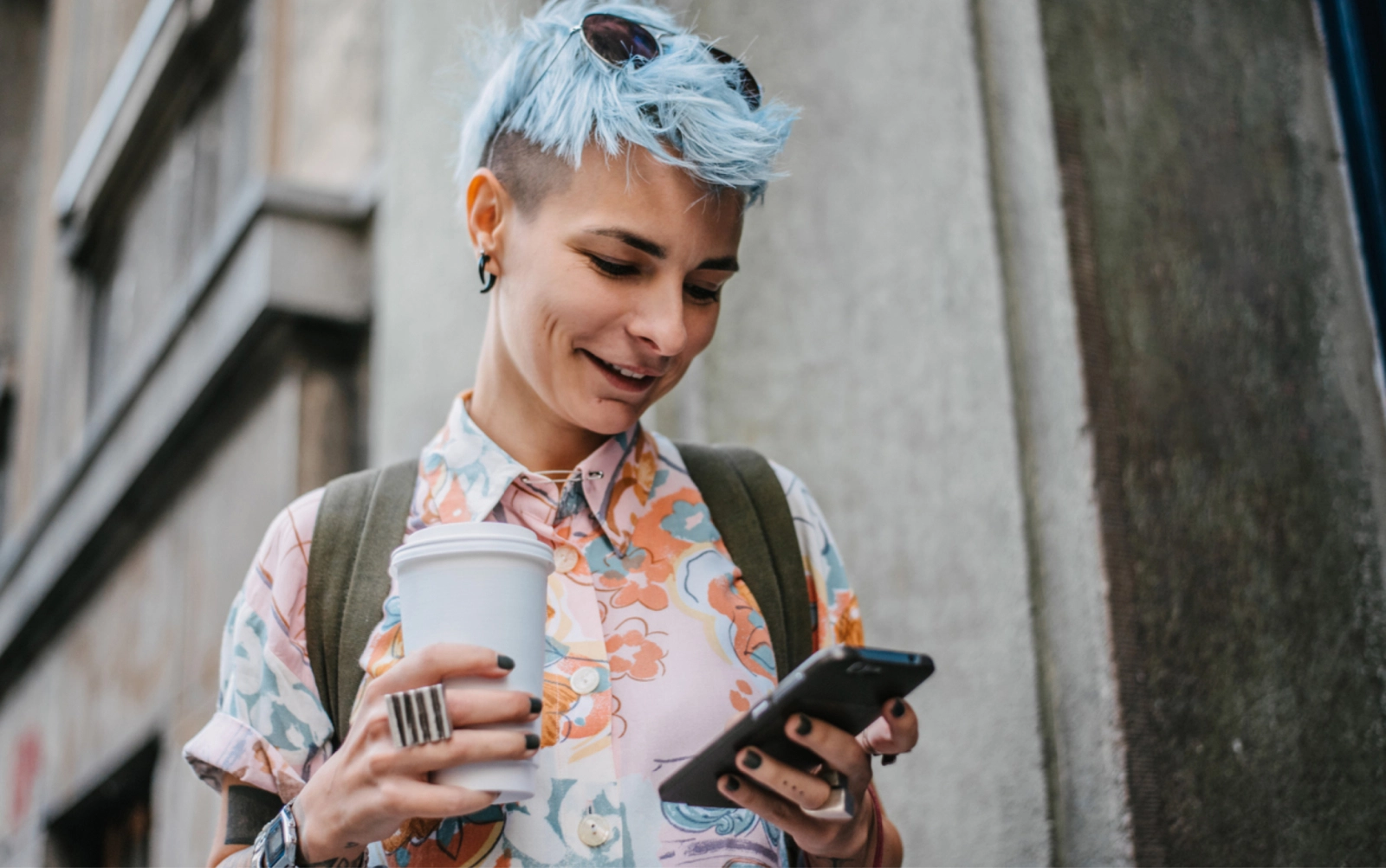 Person drinking coffee and looking on smartphone