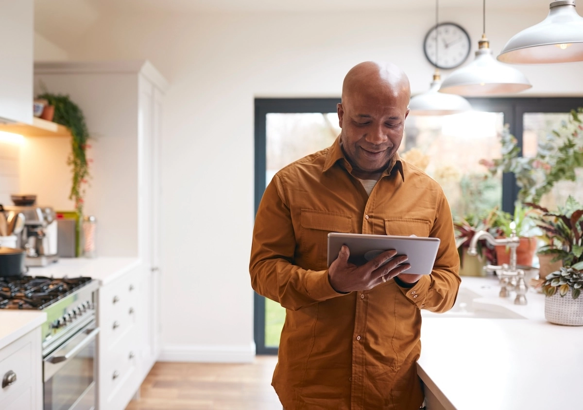 Family man using ipad in kitchen.