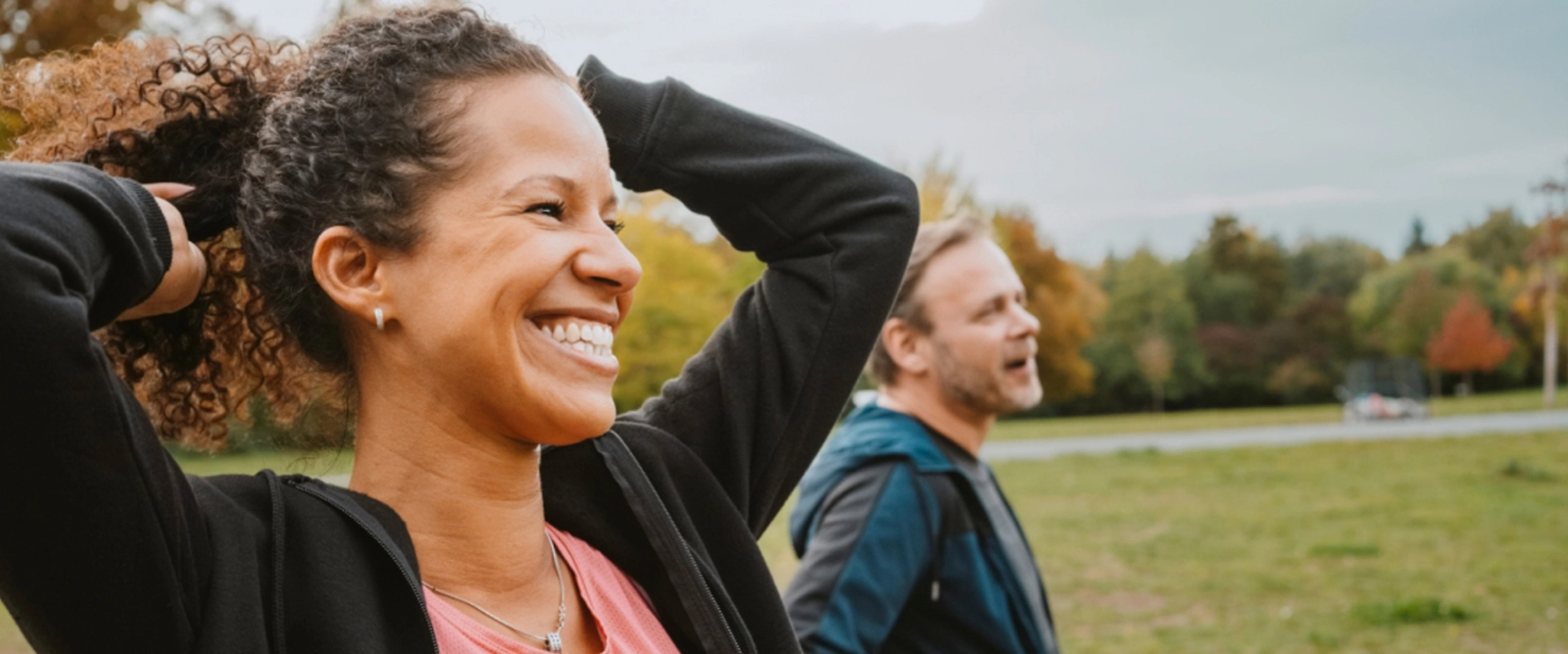 Woman holding hands over her head smiling