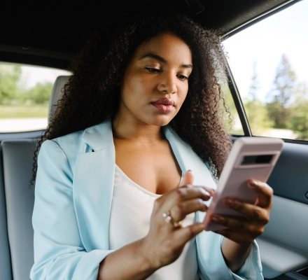 Woman using Included Health app in her car on her mobile phone.
