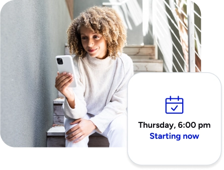 Woman sitting on stairs using her phone for a therapy session.