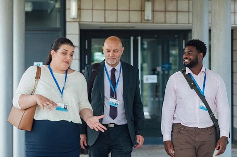 3 coworkers walking out of a building together