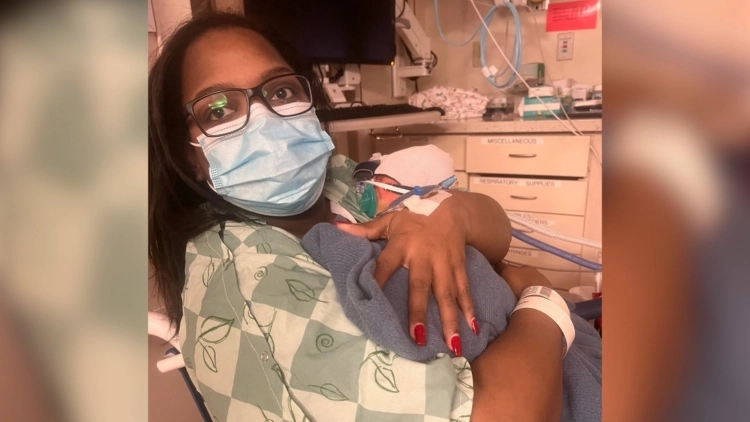 Rachell Dumas, MSN, RN is a Nurse Care Manager at Included Health seen holding her child.