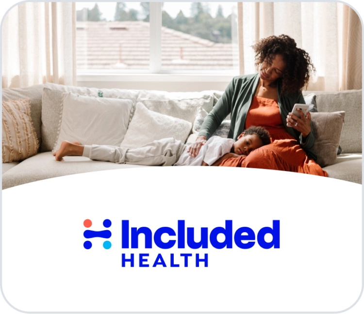 A mother with dark, curly hair sits on a couch while looking at her smartphone. Her child is lying with their head in her lap, appearing to be sick or resting. The "Included Health" logo is overlaid on the bottom of the image.