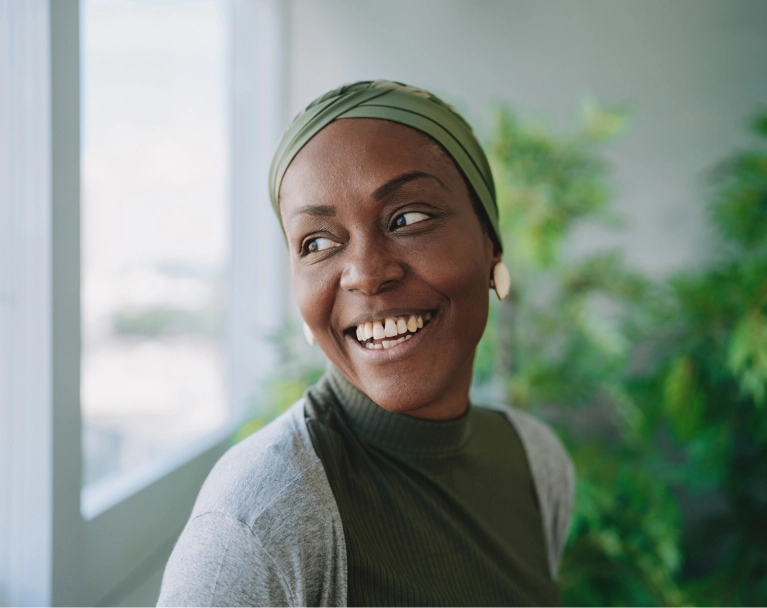 Smiling woman with headscarf looking out the window