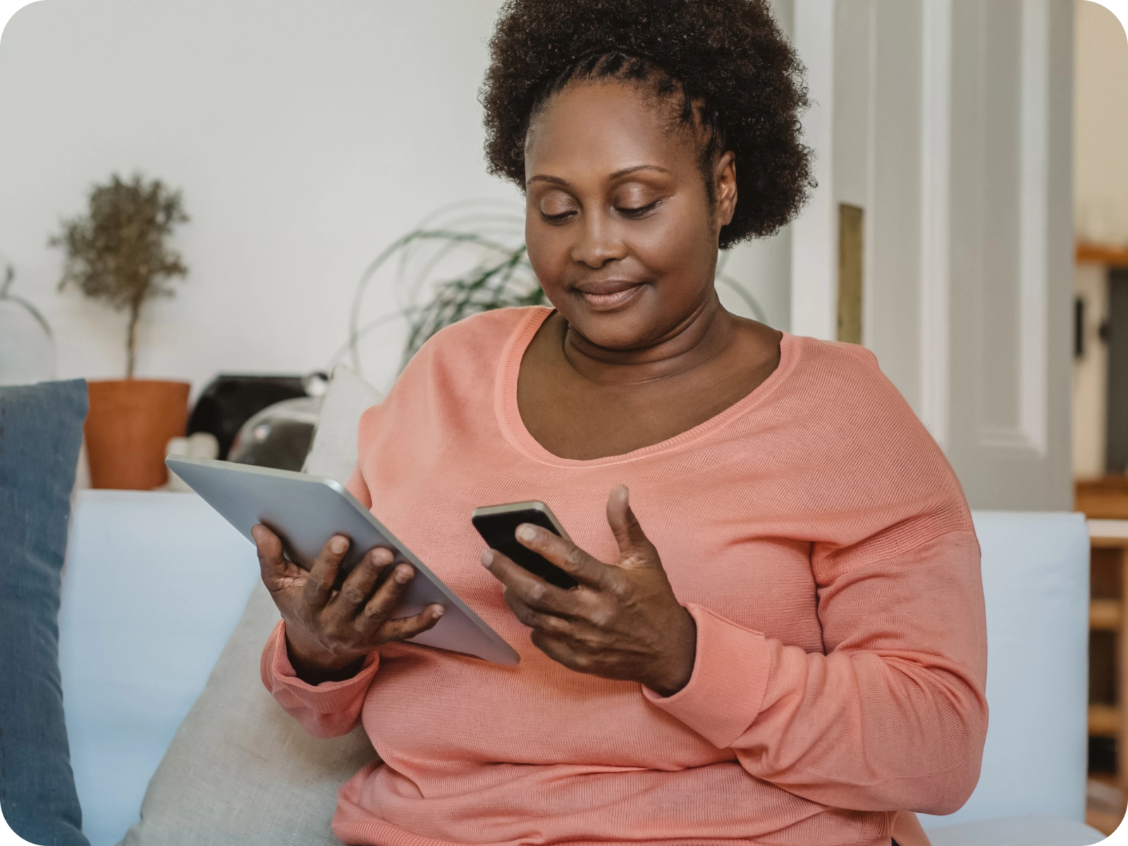 A woman holding a tablet and an phone