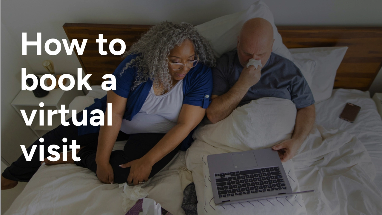A couple in bed booking a telehealth visit