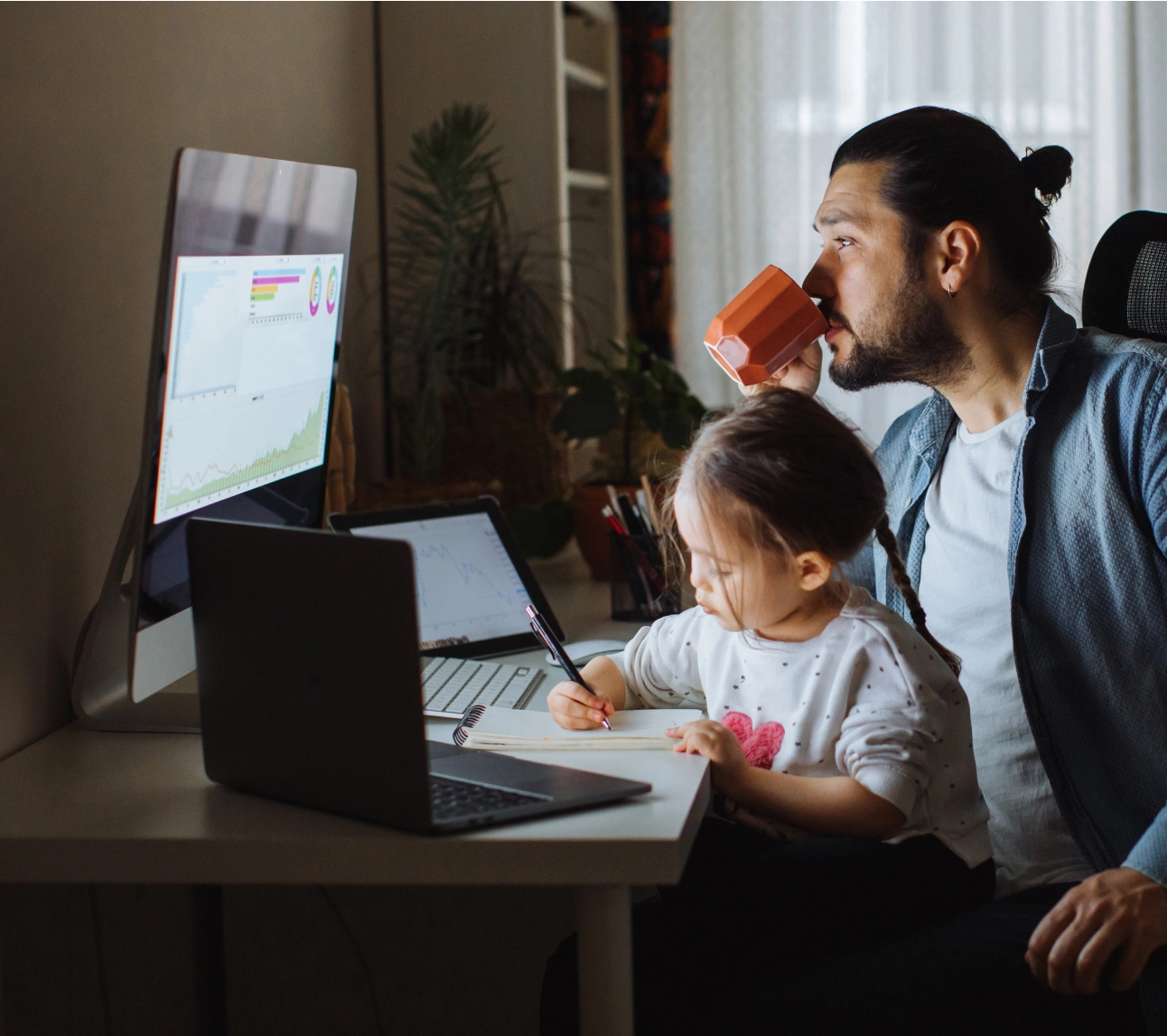 Father and daughter in front of computer screens