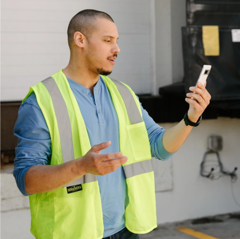 Man in yellow vest with smartphone