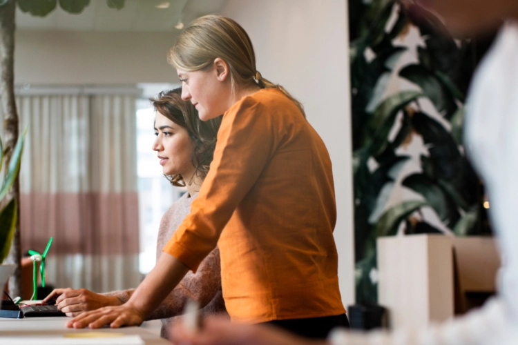 two woman looking at computer screen